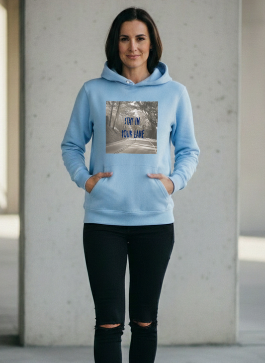 Person wearing a light blue hoodie with a graphic design, standing in an urban setting.