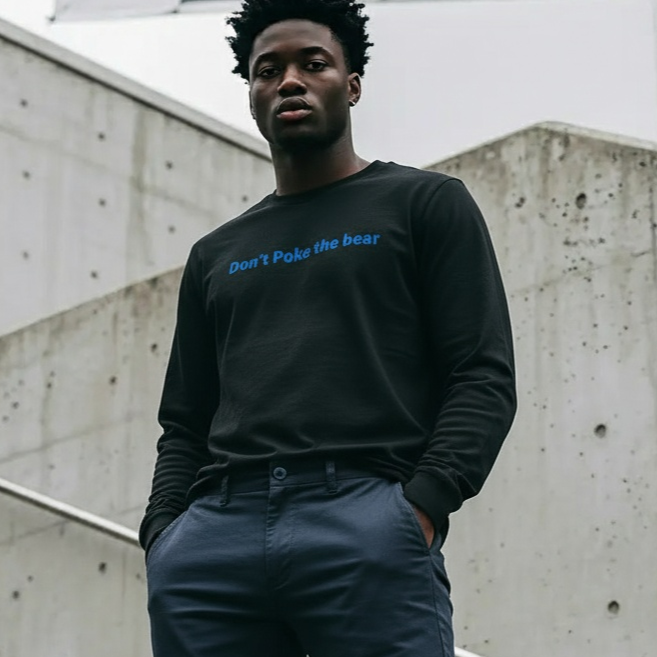 Man wearing a black sweatshirt and navy pants standing on concrete steps.